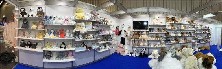 Plush toys displayed on shelves at a trade show booth