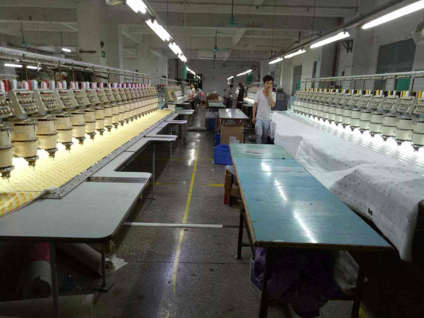 Rows of multi-head embroidery machines working over fabric