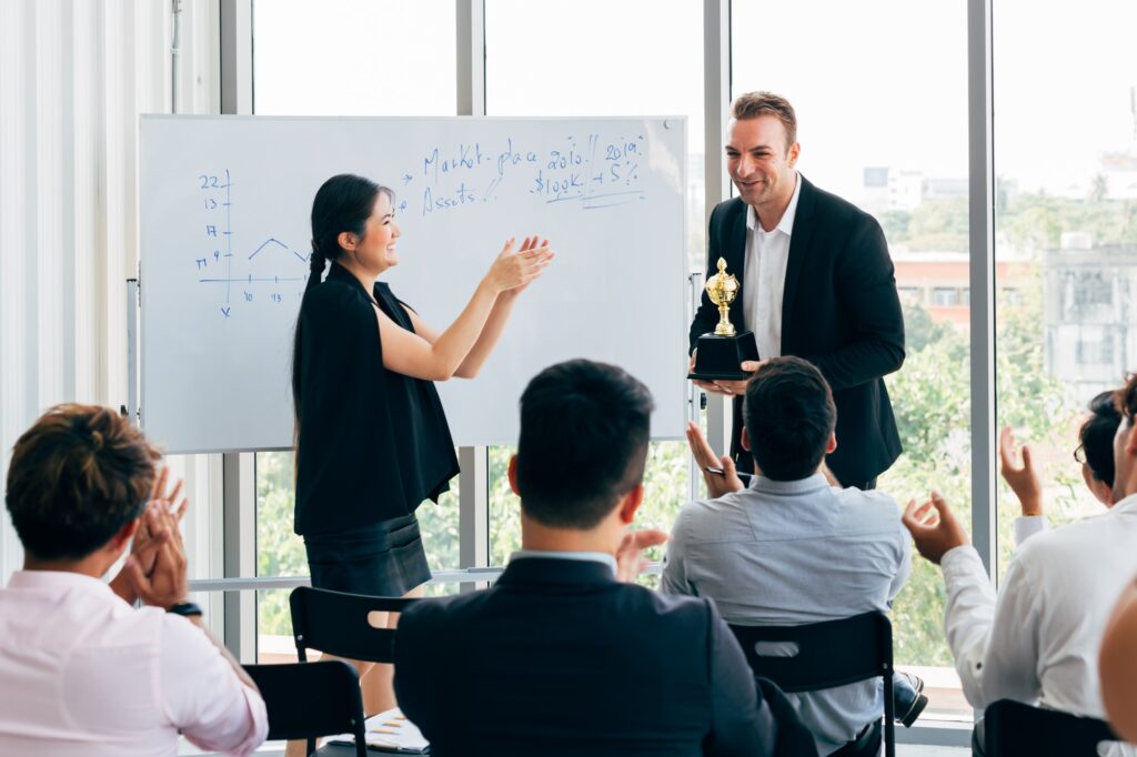Aokuma Toy management awarding factory workers at a staff meeting