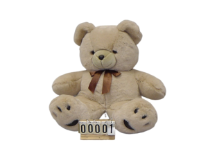 Tan plush teddy bear with brown ribbon bow and sample number tag 00001