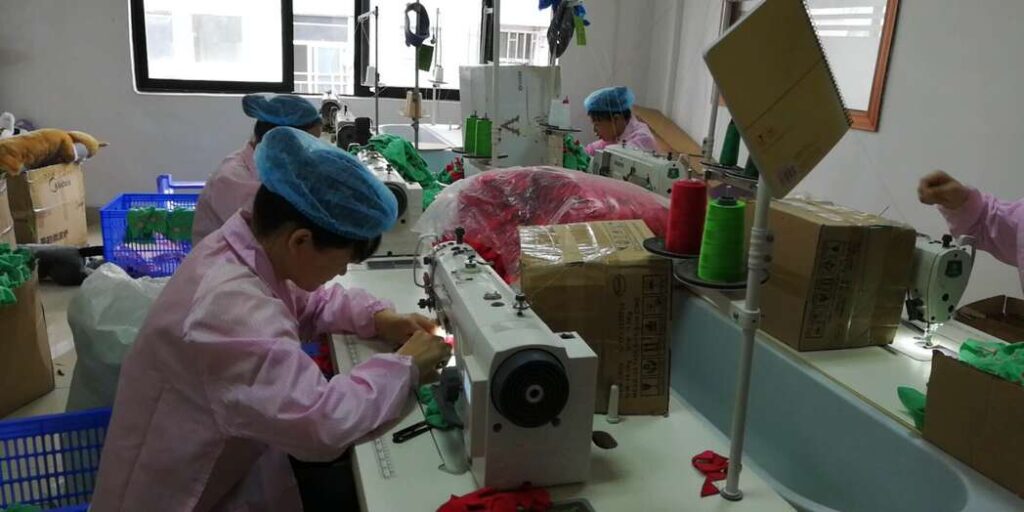 Operators sewing fabric components at sewing machines